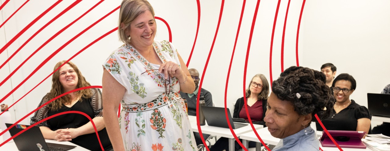 Dr. Kim Johnson talking with PhD students in classroom